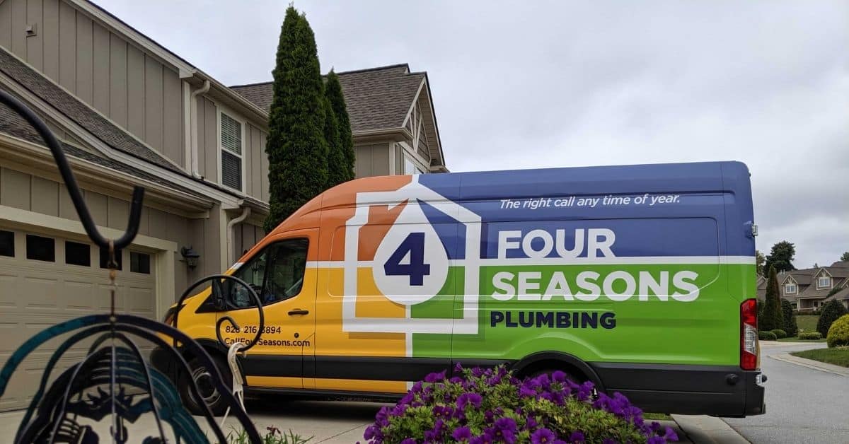  Four Seasons Plumbing service van parked in a residential driveway outside a home in North Carolina.