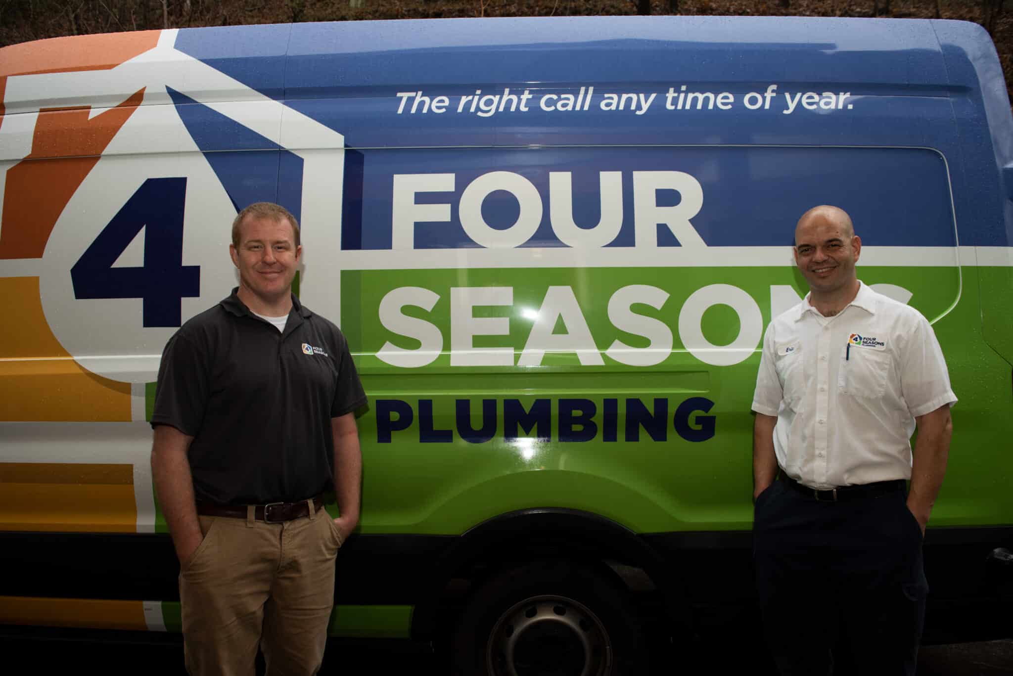 Two men stand in front of a Four Seasons Plumbing van displaying the company logo and slogan, "The right call any time of year.