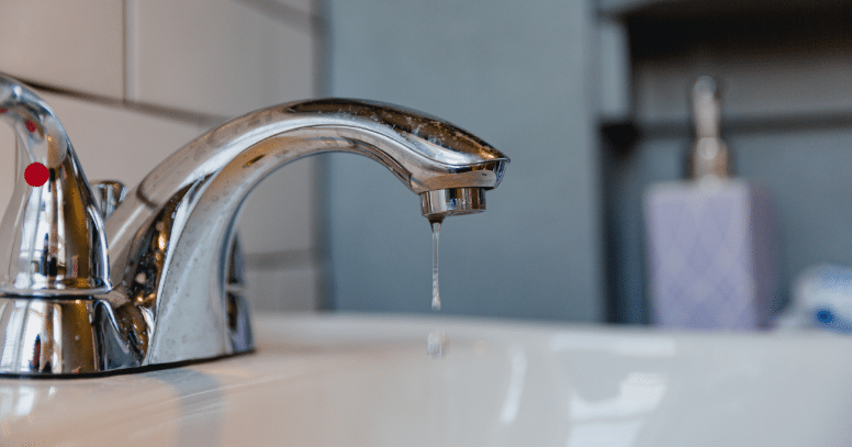 A water hose is leaking at a joint, with digital graphics indicating the leak and the word "Leaking" highlighted on the right side.